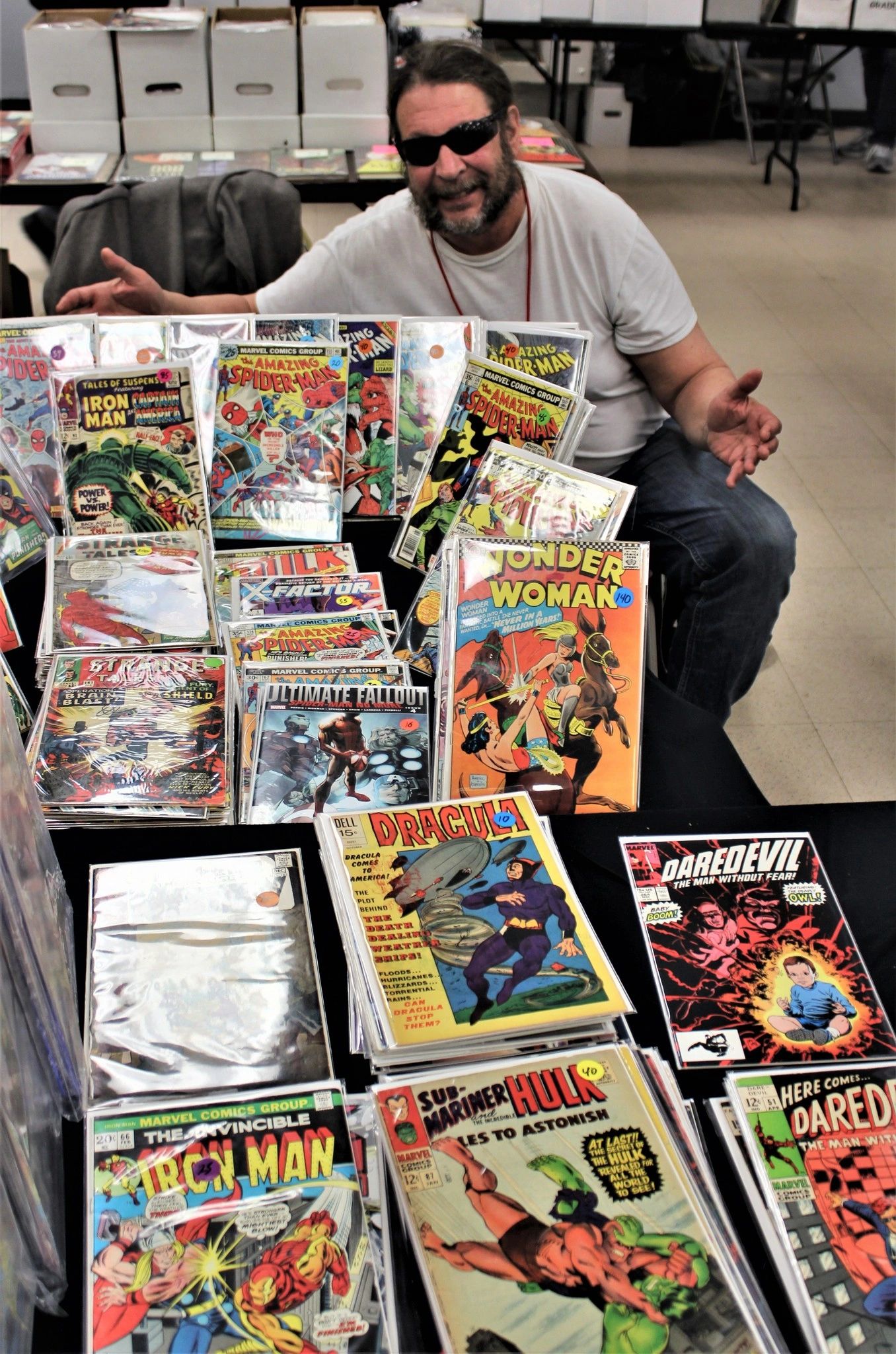 Vendor displaying vintage Marvel and DC comics